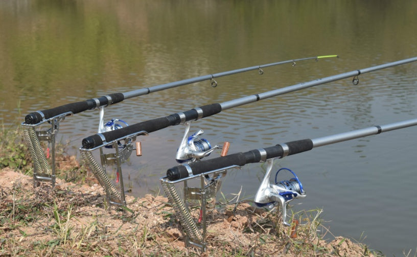 Three fishing rods with automatic hook setters set up on waterside - multi-rod fishing setup perfect for Qatar beach fishing and Gulf waters, hands-free fishing system